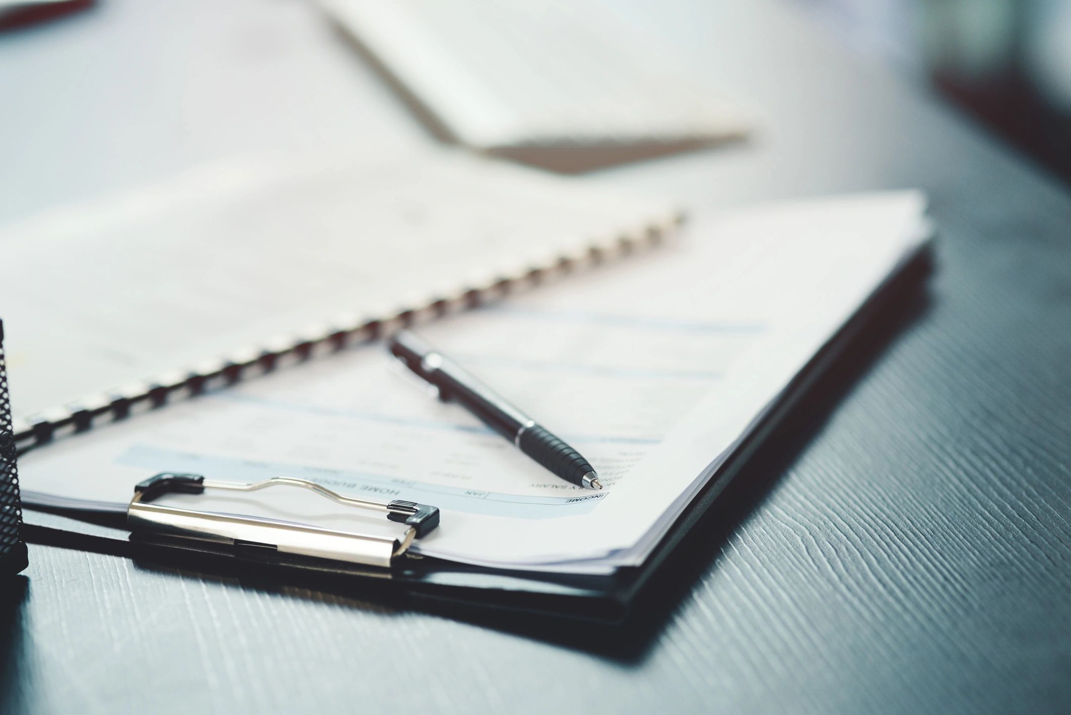Notebook and pen on a desk representing financial planning